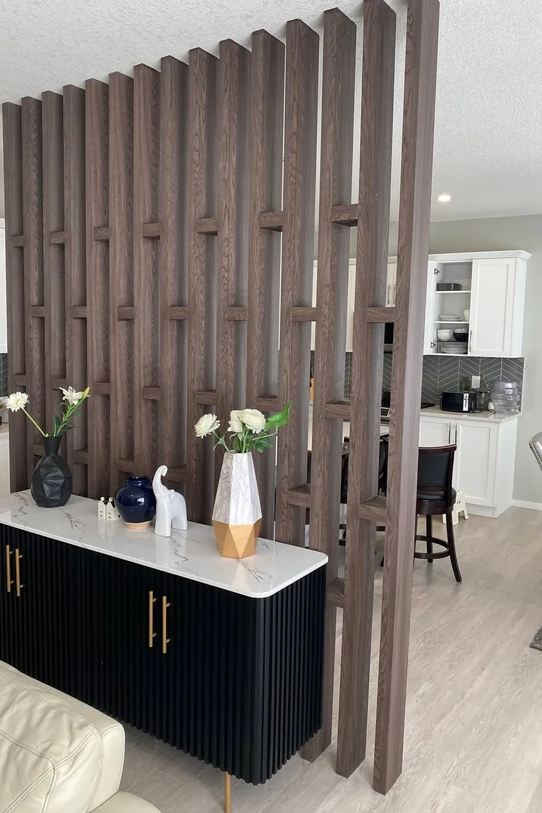 18 Small Kitchen Partition Ideas 5 Dark wood vertical slat screen with a black sideboard in front, kitchen visible beyond