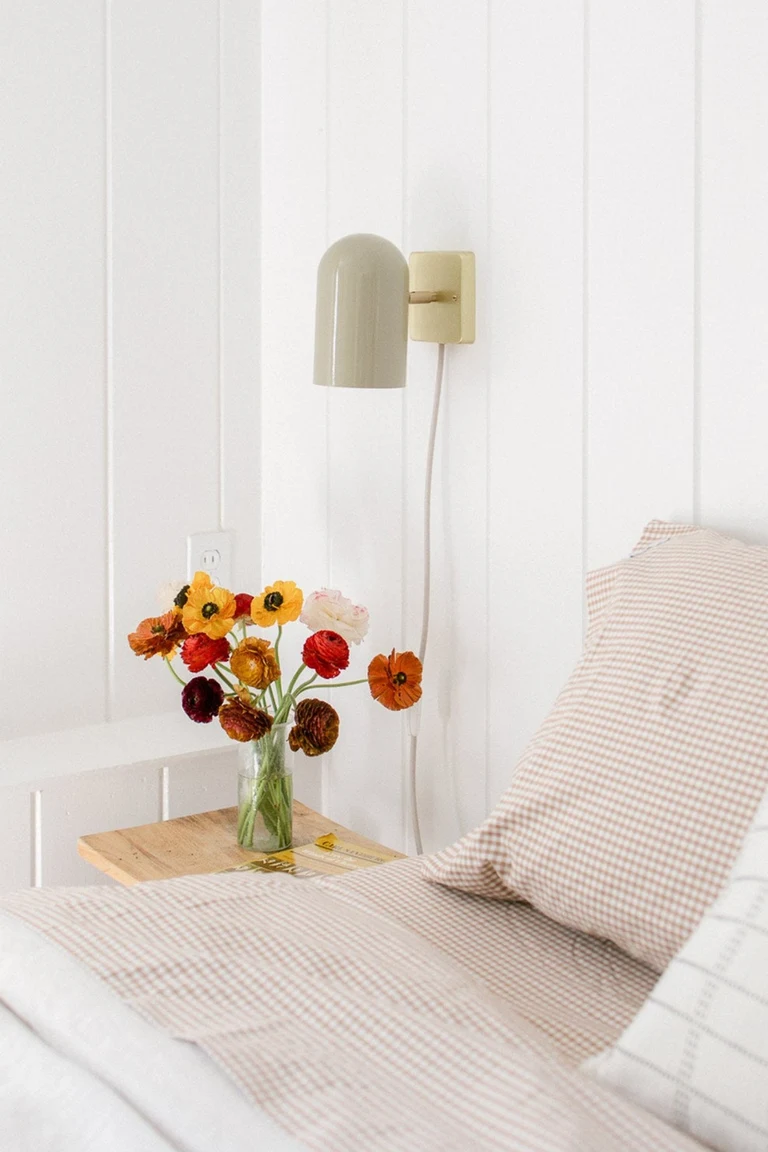20 Renter-Friendly Bedroom Ideas for a Cozy Space Without Painting 7 Plug in wall sconce with its cord running down the wall beside a bed in a rental bedroom