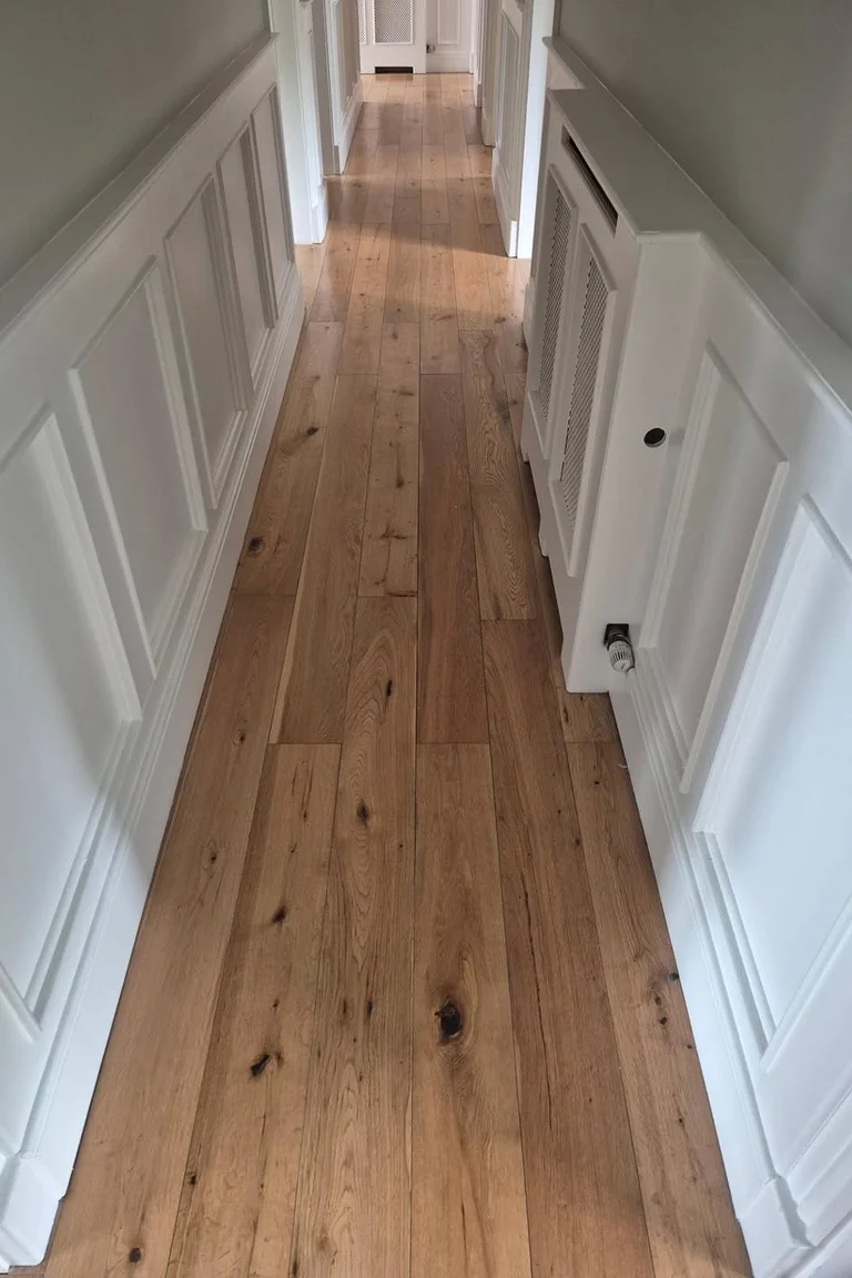 Hallway with white wainscoting and warm oak plank floors