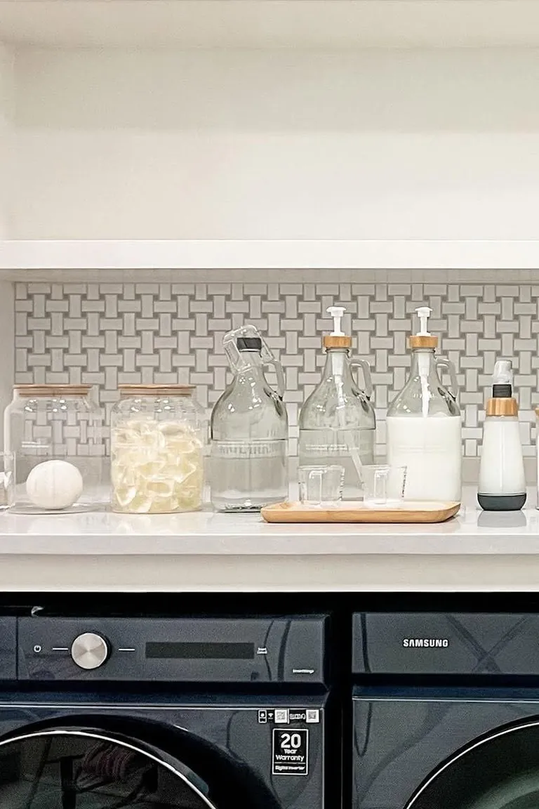 Clear dispenser bottles and jars lined up on the counter above the machines