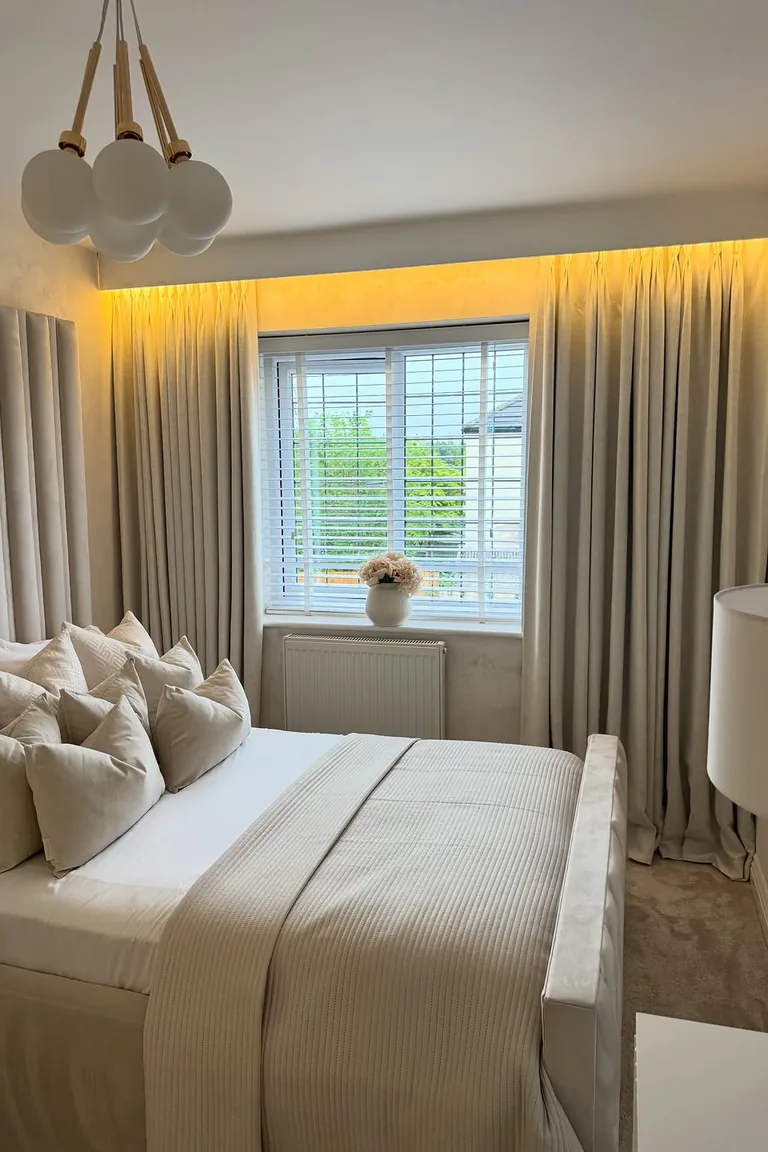 20 Renter-Friendly Bedroom Ideas for a Cozy Space Without Painting 9 Freestanding upholstered headboard on a cream and beige bed in a rental bedroom with no wall mounting