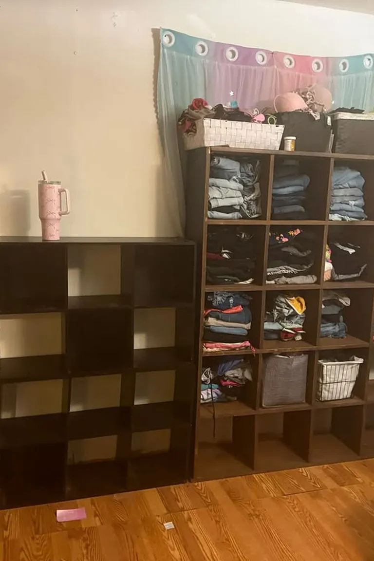 Stunning Kallax Bedroom Transformations You Need to See 9 A bedroom corner with two large dark cube shelving units filled with folded clothes and storage baskets, against a wall with a pastel curtain