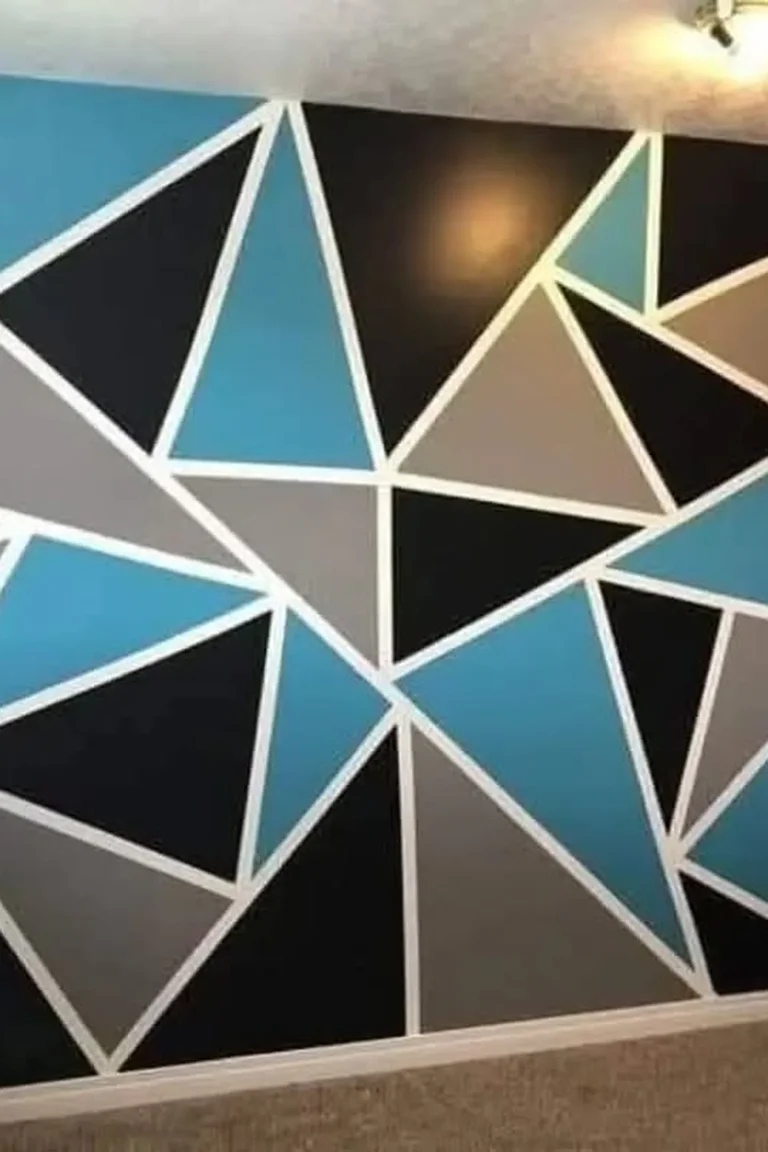 25 Stunning Accent Wall Ideas for Every Room and Style 10 A teen bedroom with a full geometric triangle accent wall painted in bright blue, charcoal, and grey behind bunk beds, with a desk edge, carpet, and ceiling light