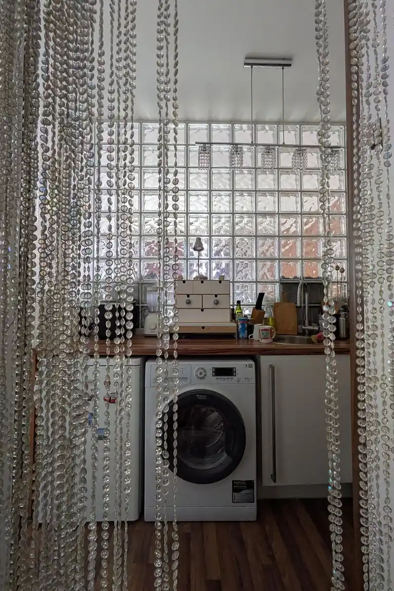 18 Small Kitchen Partition Ideas 12 Compact kitchen and laundry area framed by a hanging crystal bead curtain