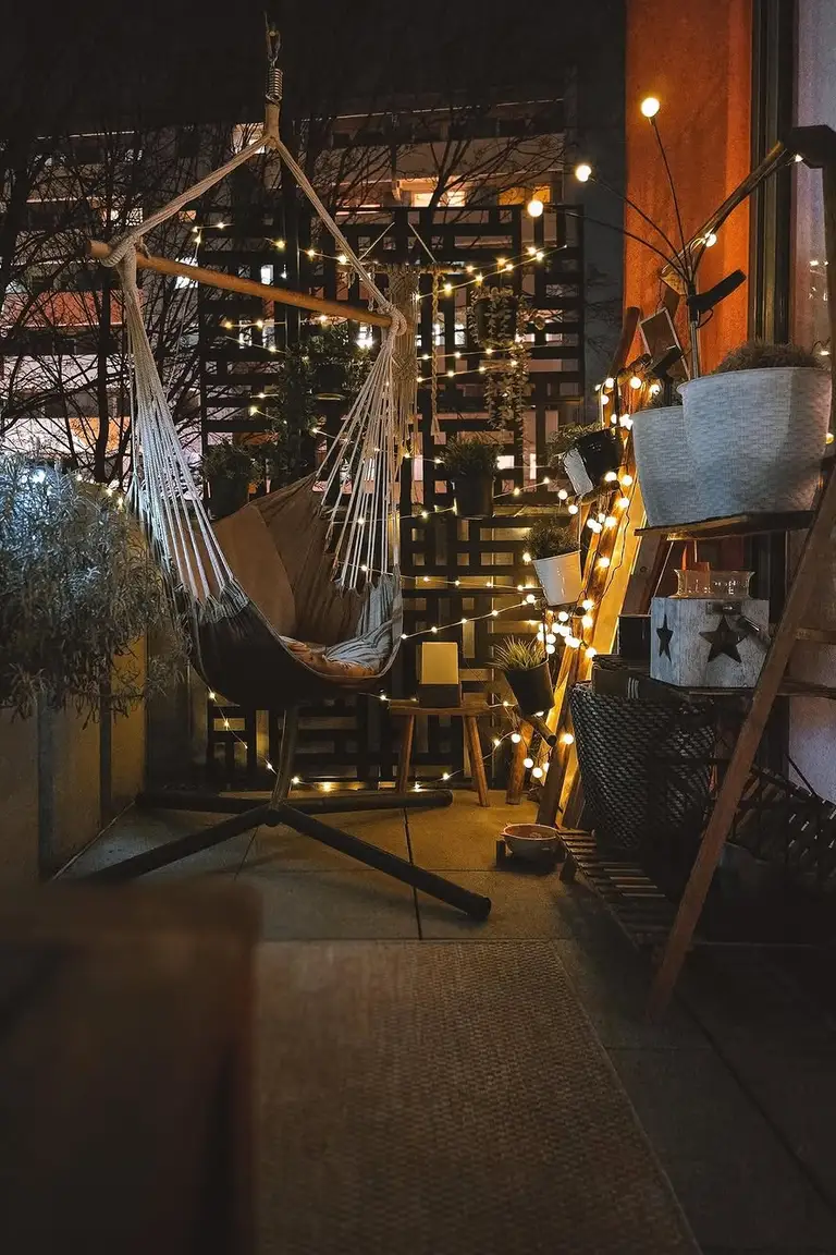 Freestanding hammock chair in the corner of a small apartment patio