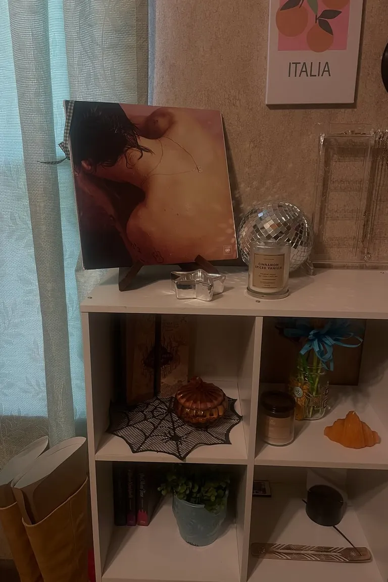 Stunning Kallax Bedroom Transformations You Need to See 17 A white two-by-two cube shelf in a bedroom corner topped with a vinyl record on a stand, a candle, and a disco ball, with art prints on the wall above