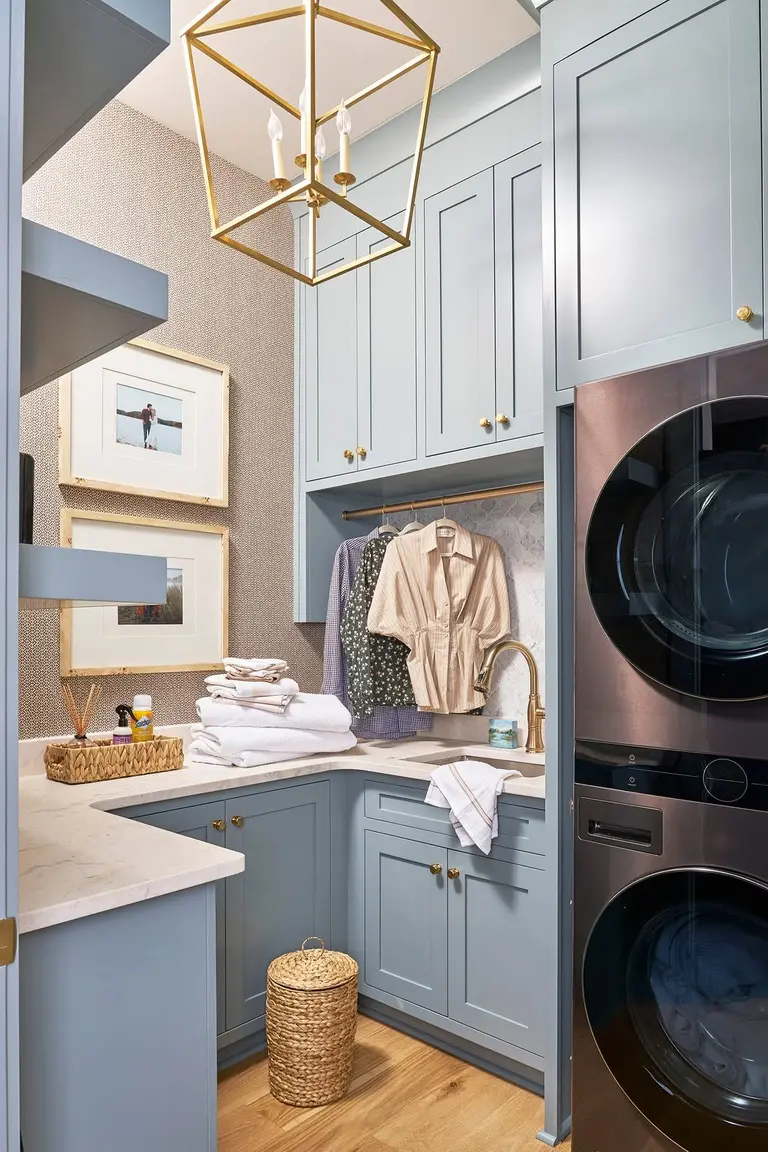 Shirts on hangers drying on a rod under laundry room cabinets
